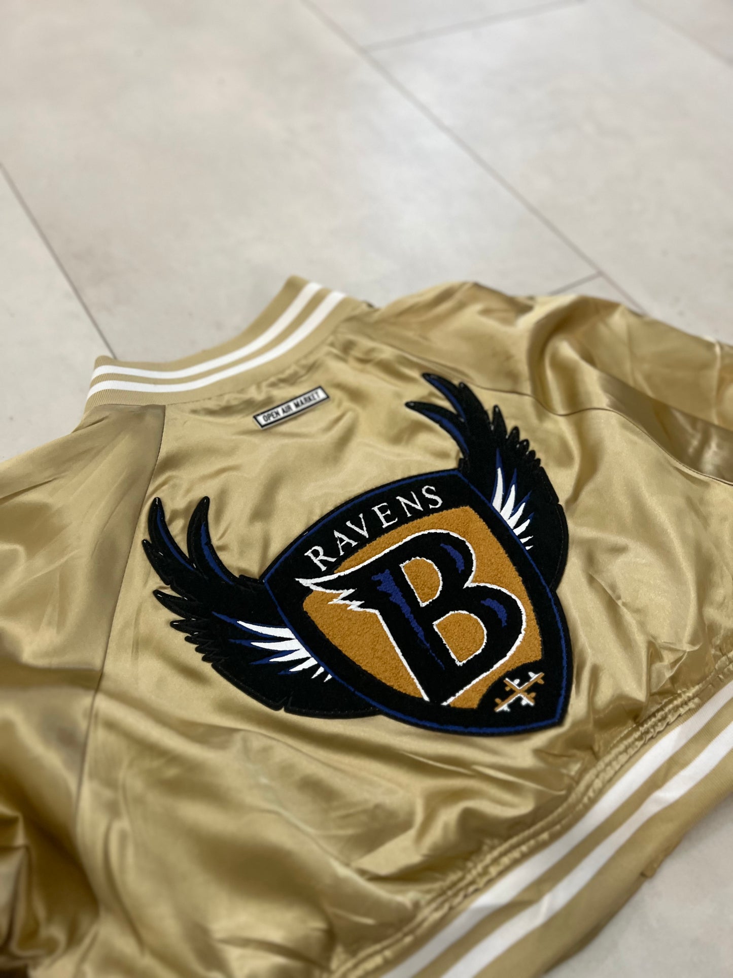 Cropped Satin “Ravens” sideline jacket.